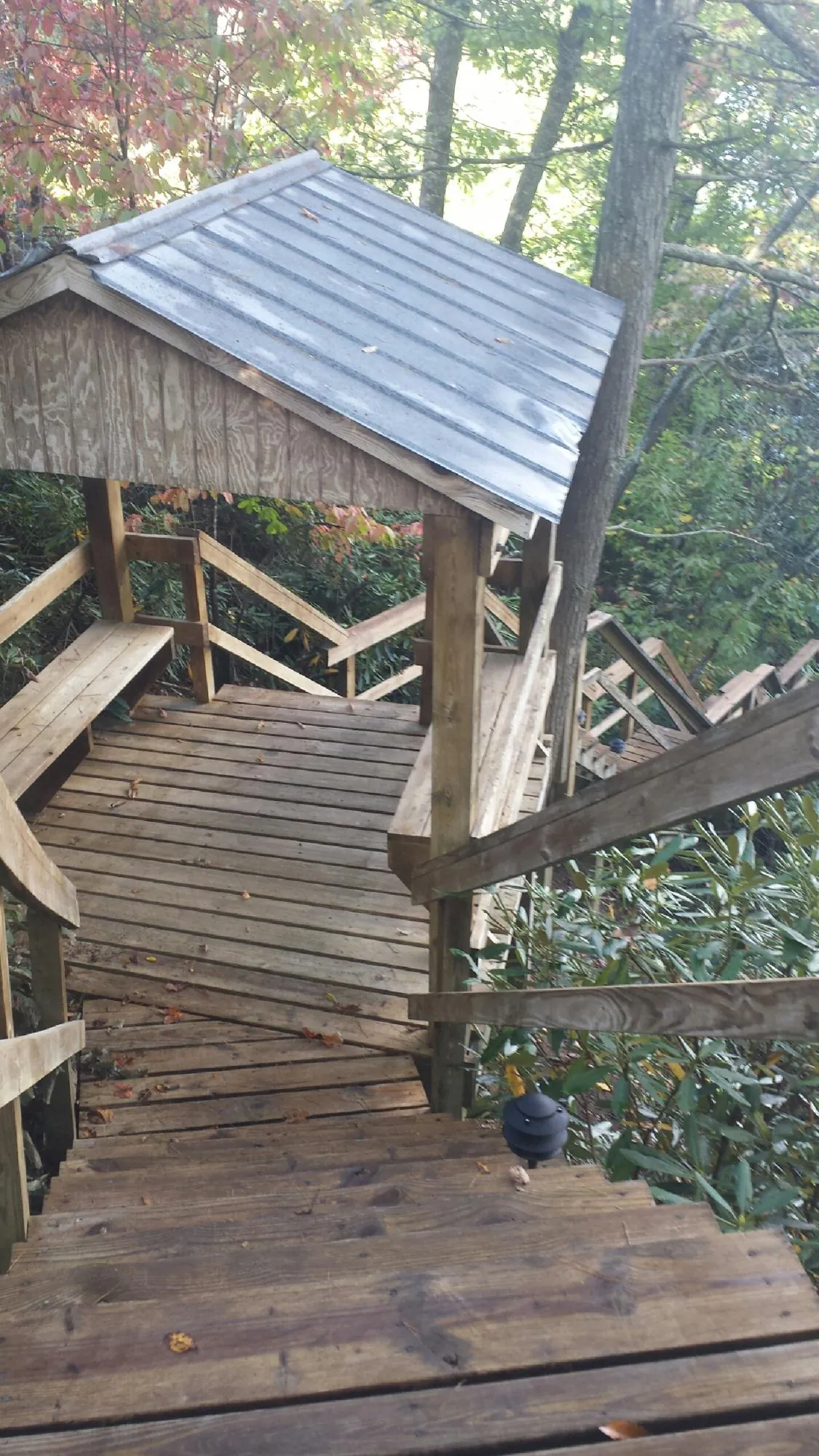 Metal roofed shelter over wooden steps on a wooded walkway — Skylight Repair & Installation work by our crew in Sequatchie