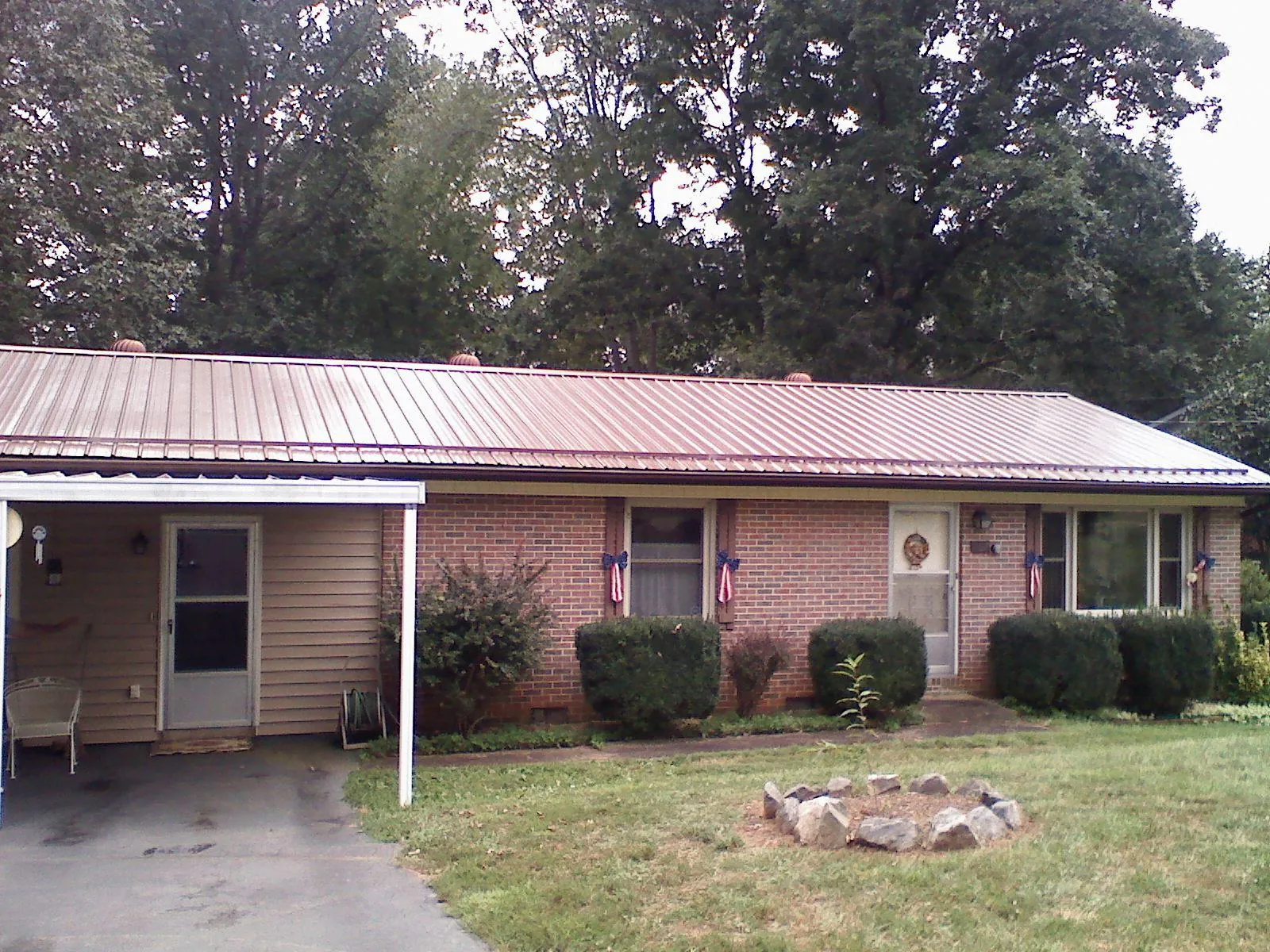 Bronze metal roof and carport on a brick ranch home — Roof Repair work by our crew in Sequatchie